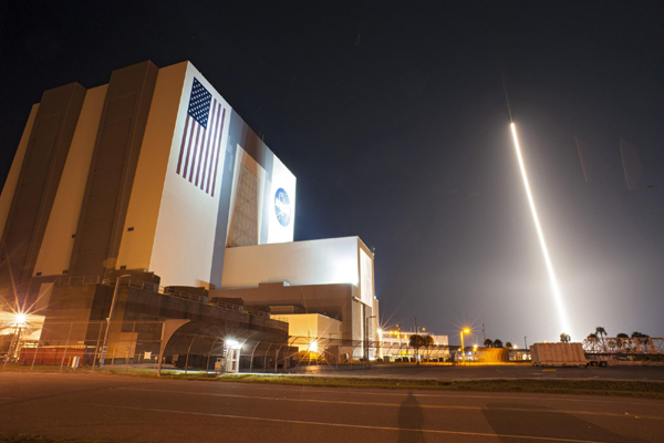 The United Launch Alliance Atlas V 401 rocket lifts off past the Vehicle Assembly Building carrying NASA's Tracking and Data Relay Satellite-K, TDRS-K, at the Cape Canaveral Air Force Station, Florida, in this Jan 30, 2013 handout image courtesy of NASA. NASA launches TDRS-K spacecraft