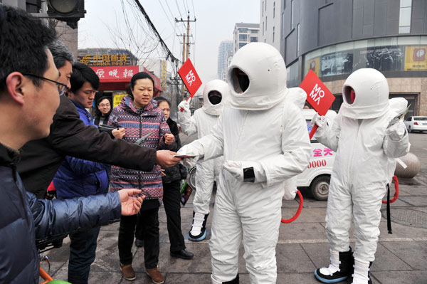 A man dressed as an astronaut hands out free masks on a street in Taiyuan city of North China’s Shanxi province – one of China’s coal mine hubs - on Jan 31, 2013. 'Astronauts' hand out free masks in N China