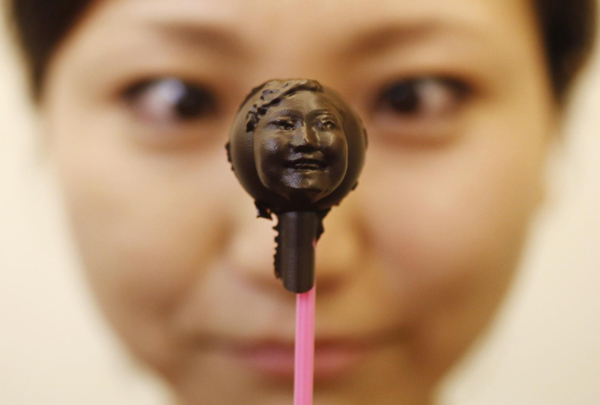 Mariya Kawae, 30, holds a piece of chocolate made in the shape of her face at a workshop ahead of Valentine's Day in Tokyo February 9, 2013. Personalized gifts for your Valentine