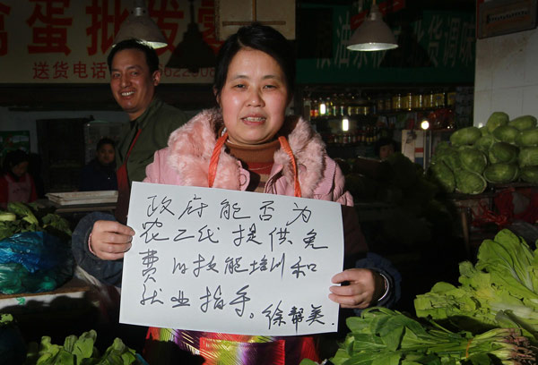 “I hope the government could offer free trainings and career guidance for the next generation of farmers,” Xu Bangmei, a vegetable vendor displays on a piece of paper in Shanghai, Feb 28, 2013. Sign of times from people to congress