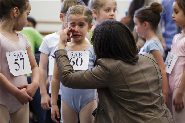 The mother of young ballet dancer Kyra Neamonitakis wipes a tear from her eyes before sending her into auditions for six-year-olds at the School of American Ballet (SAB) at Lincoln Center in New York, April 5, 2013. Young ballet dancers in auditions