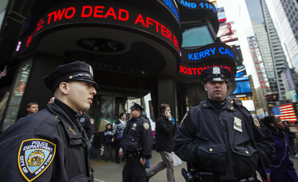 New York Police Department officers stand in the Times Square district of New York underneath a news ticker displaying details from fatal explosions in Boston, April 15, 2013. Security beefed up in US after Boston blast
