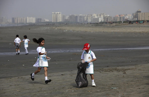 Schoolchildren collect rubbish from Karachi's Clifton beach early morning April 22, 2013, during a cleaning campaign as part of the commemoration of Earth Day. Earth Day marked around the world