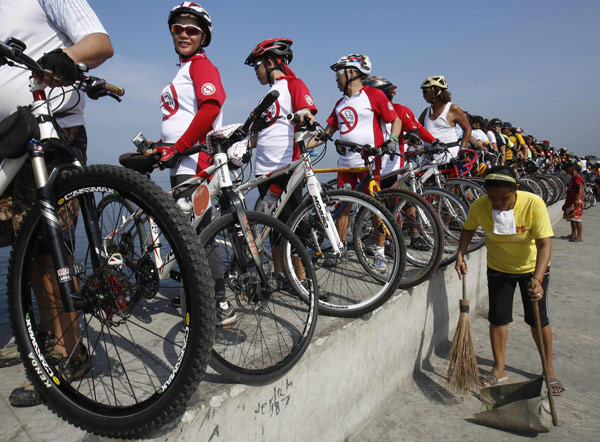 People stand with their bicycles lined up on a sea wall as they take part in the 'Save Manila Bay' event during Earth Day celebrations in Manila April 21, 2013. Earth Day marked around the world