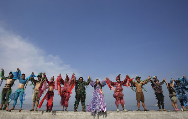 Environmentalists and artists from the Cultural Center of the Philippines, wearing costumes, join hands as part of the 'Save Manila Bay' event during Earth Day celebrations in Manila April 21, 2013. Earth Day marked around the world