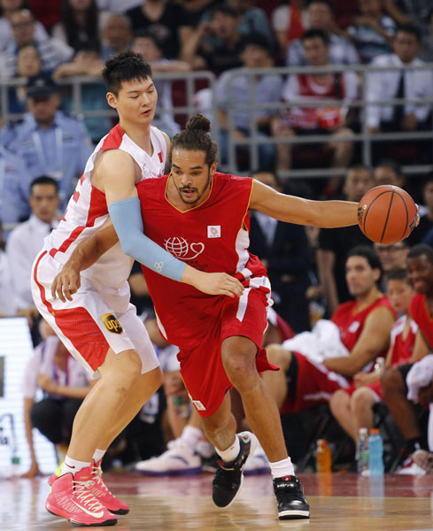 Chicago Bulls center Joakim Noah, right, drives a ball against Chinese national team's Wang Zhelin during a charity basketball match between NBA All-star team and Chinese national team in Beijing, July 1, 2013. Yao Ming, McGrady team up for charity