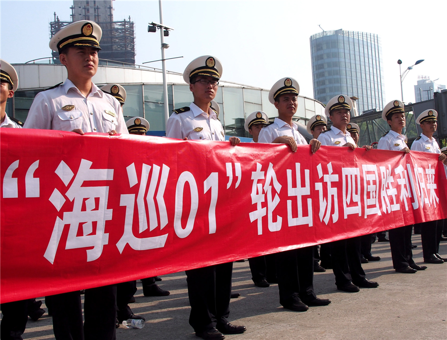 Soldiers hold a welcome banner at a port along Huangpu River in Shanghai as Haixun 01 returns home China's flagship vessel returns from record voyage