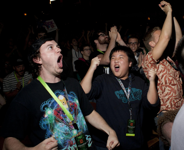 Fans Ian Odom (front L) and Moss Pholchalernchit (front 2nd L) cheer during 'The International' Dota 2 video game competition in Seattle, Washington August 11, 2013. Gamers storm Seattle for Dota 2 competition
