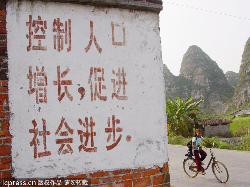 “Curb population growth, promote social progress,”reads a sign in Longhui county, Southwest China’s Yunnan province, Oct 7, 2004. When family planning slogans dominated walls