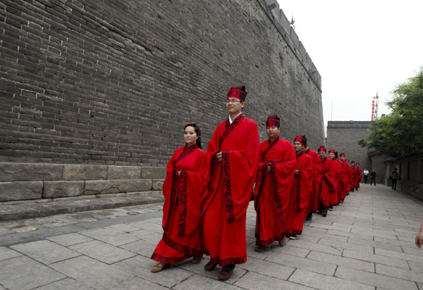 Couples in traditional Han Dynasty costumes take part in a group wedding ceremony in Xi’an on May 1, 2012. Couples wed in ancient style