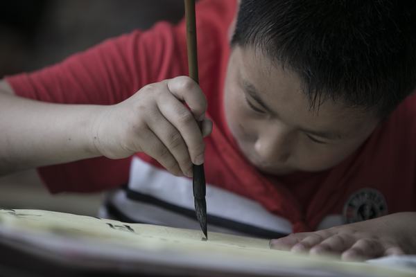 認(rèn)真撰寫毛筆字的塘市小學(xué)學(xué)生