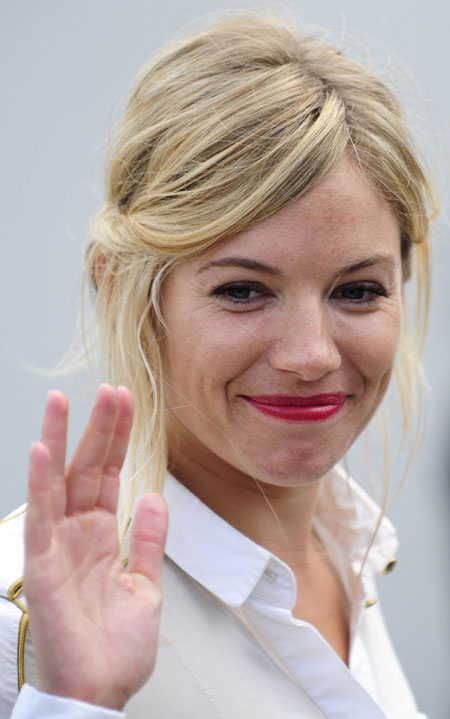 Sienna Miller poses for photographers during a photocall to promote
