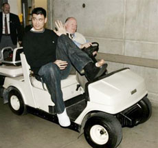 Houston Rockets center Yao Ming, of China, is driven from the arena locker room by security director Al Higham after his NBA basketball game against the Utah Jazz on Monday, April 10, 2006, in Salt Lake City. Yao broke his left foot in the first quarter. The Jazz beat the Rockets, 85-83. (AP