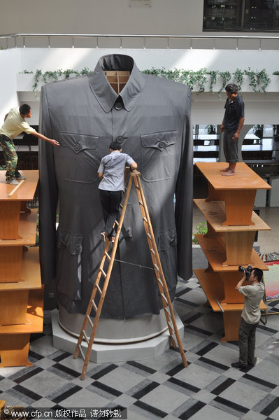 Workers arrange a huge Zhongshan suit located at Zhejiang Textile and Fashion College in Ningbo, Sept 14, 2011. Huge Zhongshan suit towers high in E China