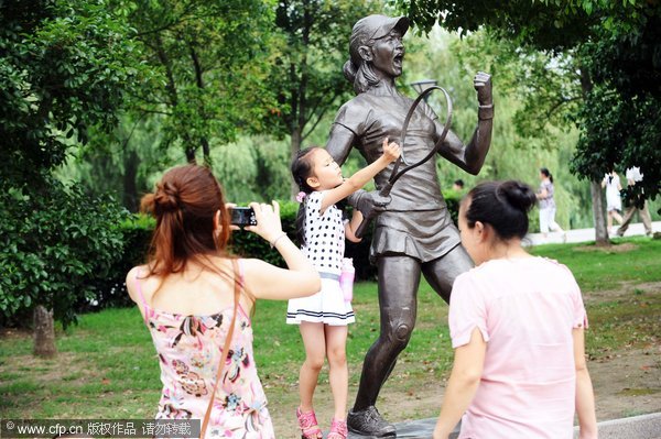 A girl poses for a photo with a statue of Li Na at a square in Wuhan, Central China’s Hubei province, the hometown of the tennis player who took the 2011 French Open singles title on June 4 this year. The recently-erected statue was made to honor Li, the first Chinese to win a tennis grand slam. Tennis great immortalized with statue in Wuhan
