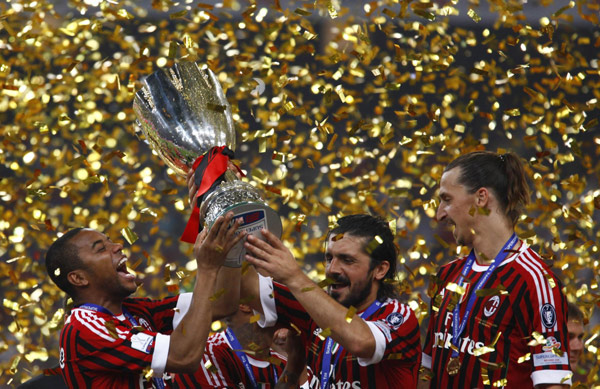 AC Milan's Robinho (L), Gennaro Ivan Gattuso (C) and Zlatan Ibrahimovic celebrate with the trophy after winning the Italian Super Cup soccer match against Inter Milan at the National Olympic Stadium, also known as the Bird's Nest, in Beijing, August 6, 2011. Milan edge out Inter in Super Cup