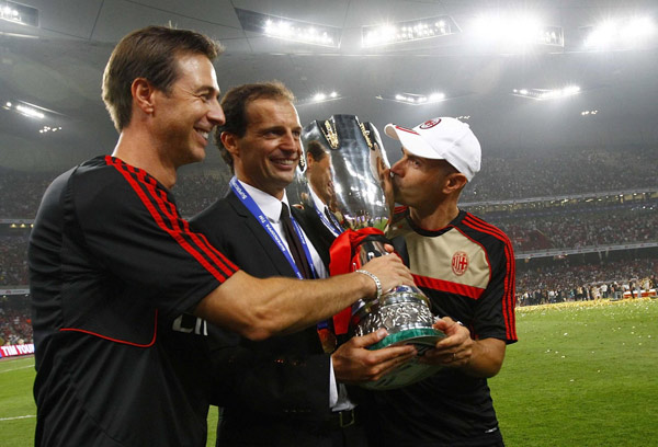 AC Milan's coach Massimiliano Allegri (C) holds the trophy with his colleagues as he celebrates after winning the Italian Super Cup soccer match against Inter Milan at the National Olympic Stadium, also known as the Bird's Nest, in Beijing, August 6, 2011. Milan edge out Inter in Super Cup