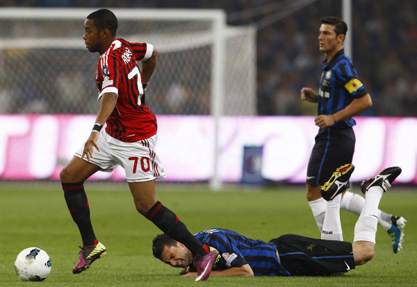 Inter Milan's Thiago Motta (C) falls as he fights for the ball with Robinho (L) of AC Milan during their Italian Super Cup soccer match at the National Olympic Stadium, also known as the Bird's Nest, in Beijing, August 6, 2011. Milan edge out Inter in Super Cup