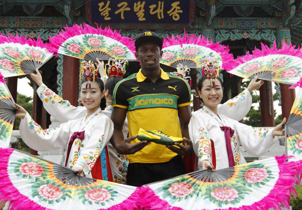 A Jamaican posing with the world's fastest man Bolt shows off new running spikes