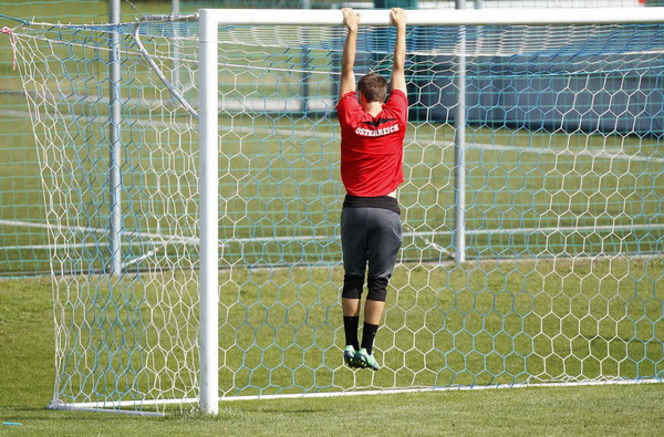 Austrian national soccer player Thomas Schrammel hangs on to a goal crossbar during a training session ahead of the Euro 2012 qualifying match against Germany in Bad Tatzmannsdorf, Aug 31, 2011. Countries warm up for the coming Euro 2012