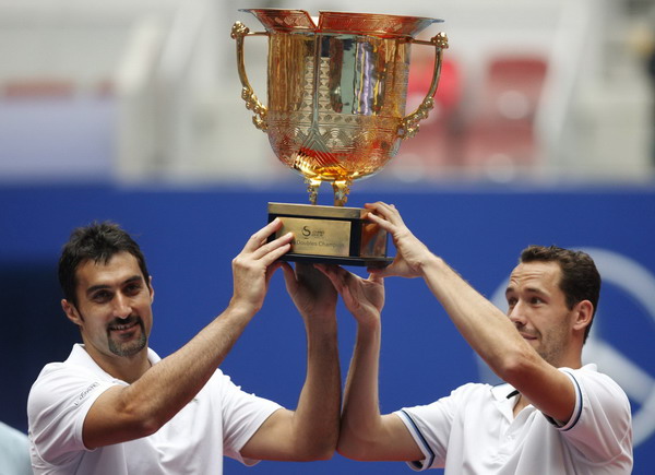 Michael Llodra (R) of France and Nenad Zimonjic of Serbia hold up their trophy after beating Robert Lindstedt of Sweden and Horia Tecau of Romania to win gold for the men's doubles final at the China Open tennis tournament in Beijing Oct 9, 2011. Llodra and Zimonjic capture China Open title