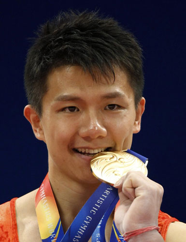 China's Chen Yibing bites his gold medal at the award ceremony for the rings during the men's apparatus final at the Artistic Gymnastics World Championships in Tokyo October 15, 2011. Chen wins rings title at gymnastics worlds