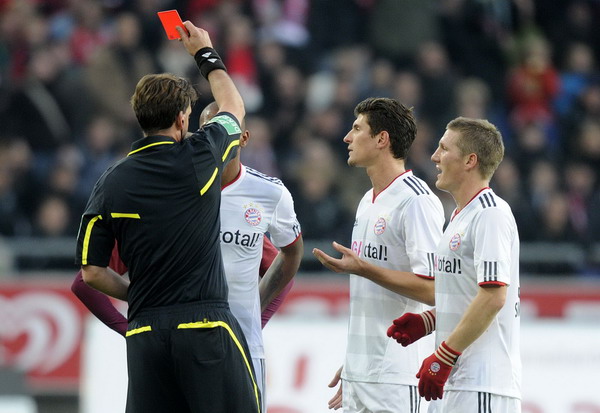 Referee Manuel Graefe (L) shows Bayern Munich's Jerome Boateng (2nd L) the red card as Bastian Schweinsteiger (R) and Mario Gomez watch, during their German Bundesliga first division soccer match in Hanover, Oct 23, 2011. Bayern's Boateng banned for two games