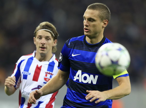 Nemanja Vidic of Manchester United is challenged by Liviu Antal of Otelul Galati during their Champions League Group C soccer match at the National Arena in Bucharest Oct 18, 2011. Serbia's Vidic quits international football