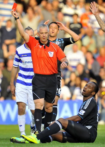 Referee Chris Foy (2L) shows Chelsea's Didier Drogba (R) the red card for his challenge on Queens Park Rangers's Adel Taarabt during their English Premier League soccer match at Loftus Road in London Oct 23, 2011. FA charge Chelsea, demand Villas-Boas explanation