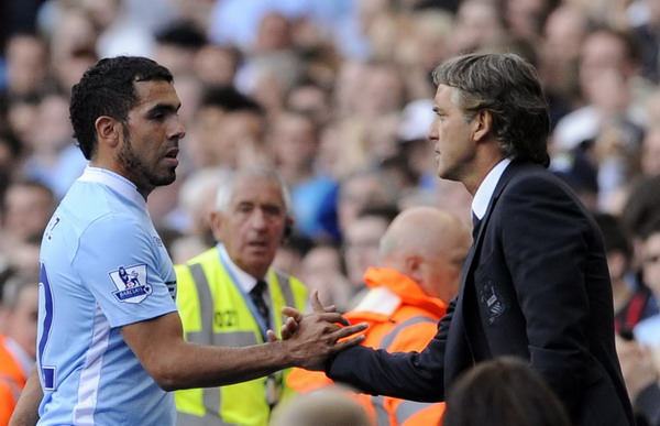 Manchester City's coach Roberto Mancini (R) substitutes Carlos Tevez during their English Premier League soccer match against Wigan Athletic in Manchester, northern England, in this file photo taken Sept 10, 2011. Tevez fined four weeks' wages by Man City
