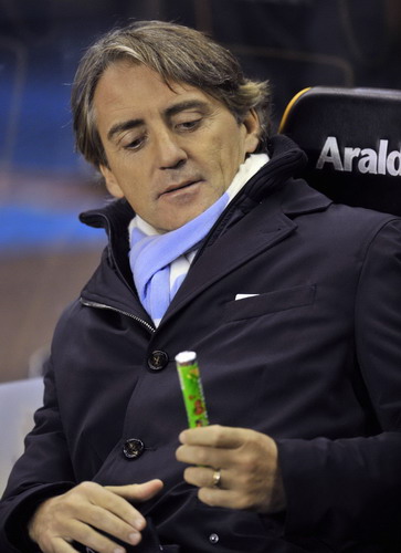 Manchester City's manager Roberto Mancini holds a tube of sweets before their English League Cup soccer match against Wolverhampton Wanderers at Molyneux in Wolverhampton, central England Oct 26, 2011. Free-scoring Man City hit five past Wolves