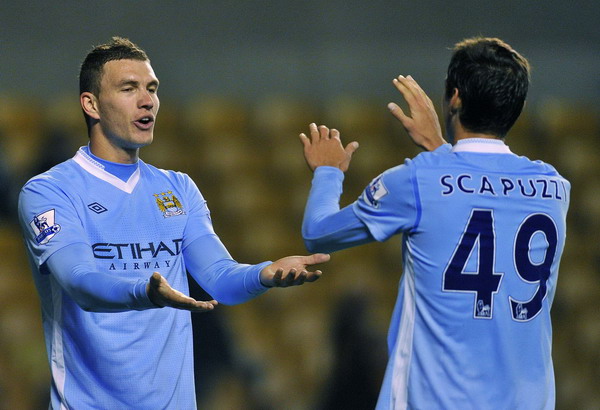 Manchester City's Edin Dzeko (L) celebrates scoring with teammate Luca Scapuzzi (R) during their English League Cup soccer match against Wolverhampton Wanderers at Molyneux in Wolverhampton, central England Oct 26, 2011. Free-scoring Man City hit five past Wolves