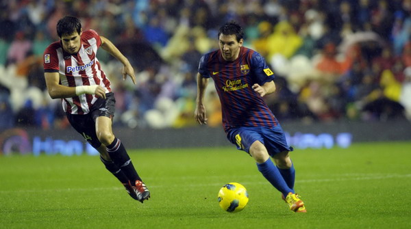 Barcelona's Lionel Messi (R) and Athletic Bilbao's Javi Martinez fight for the ball during their Spanish first division soccer match at San Mames stadium in Bilbao Nov 6, 2011. Messi rescues Barca, Real rout Osasuna
