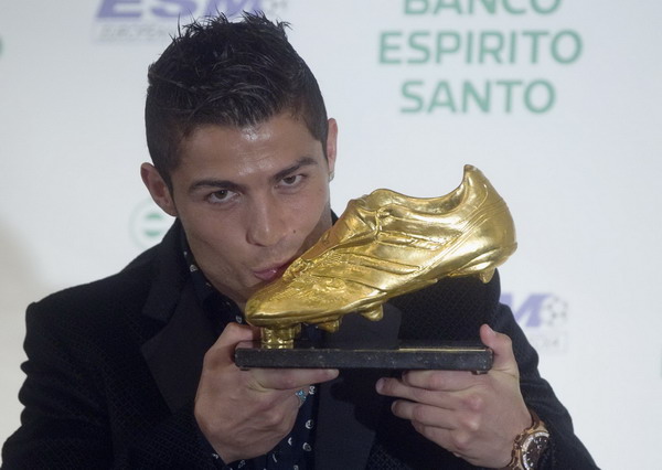 Real Madrid's soccer star Portuguese Cristiano Ronaldo kisses the European Golden Shoe trophy after receiving it in a ceremony in Madrid Nov 3, 2011. Messi rescues Barca, Real rout Osasuna