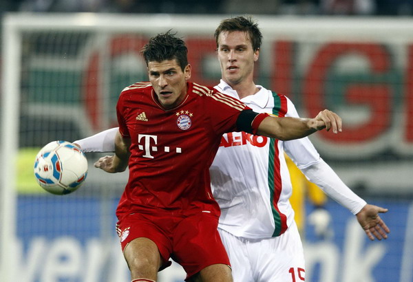 Bayern Munich's Mario Gomez is challenged by Augsburg's Sebastian Langkamp during their German Bundesliga first division soccer match in Augsburg Nov 6, 2011. Gomez scores again in Bayern win