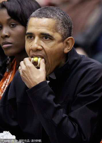 US President Barack Obama (L) and first lady Michelle Obama attend the Oregon State vs. Towson basketball game in Towson University in Maryland, Nov 26, 2011. Obama and wife attend NCAA basketball game