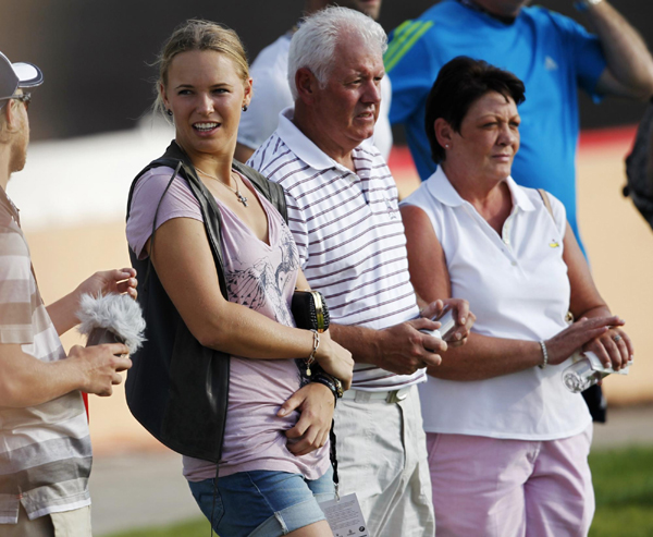 Tennis player Caroline Wozniacki of Denmark stands with the parents of his boyfriend Rory McIlroy of Northern Ireland, Rosie(R) and Gerry, as McIlroy plays during the final round of the Dubai World Championship at the Jumeirah Golf Estates in Dubai. Wozniacki spotted with McIlroy's family at Dubai Open