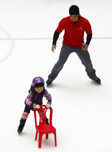 Former Olympic short track speed skating champion Apolo Anton Ohno of the US skates with a young Chinese skater during a promotion for the Special Olympics in Beijing. Apolo in Beijing for Special Olympics promotion