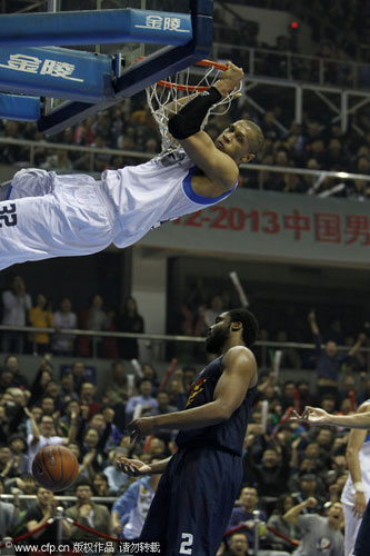 Randolph Morris, top, of Beijing Ducks slam dunks the ball against Guangdong Hongyuan during their CBA league game in Beijing, Feb 3, 2013. Beijing Ducks snaps Guangdong's 15-game winning streak