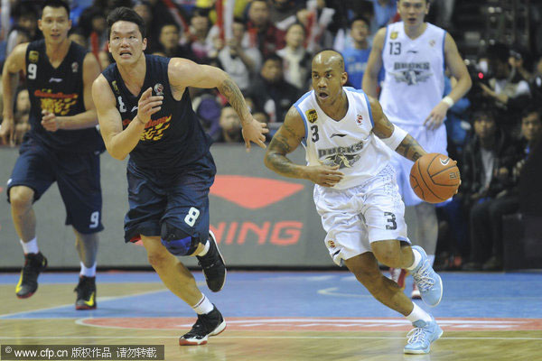 Stephon Marbury of Beijing Ducks dribbles the basketball defended by Zhu Fangyu of Guangdong Hongyuan during their CBA league game in Beijing, Feb 3, 2013. Beijing Ducks snaps Guangdong's 15-game winning streak