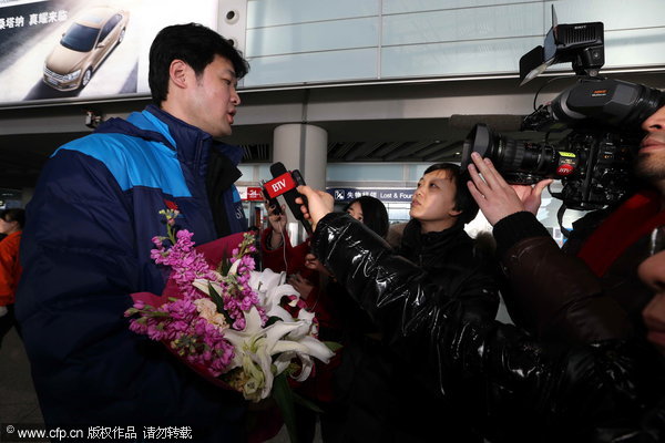 Li Mu, left, head coach of the Beijing Basic Motor volleyball club, takes interview after returning with a champion's title to Beijing, Feb 4, 2013. Chinese volleyball champion coach eyes move to West