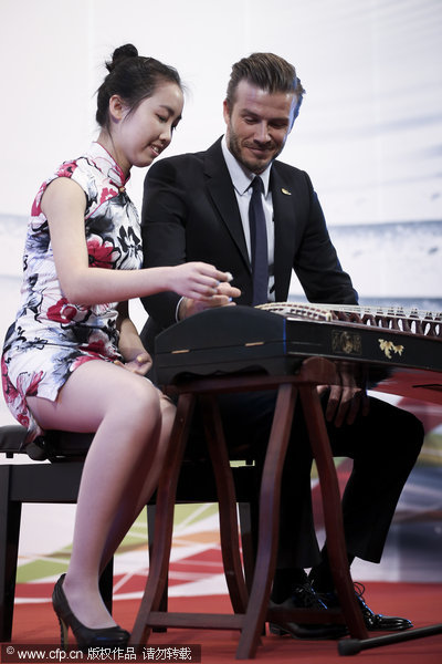 David Beckham, right, learns how to play Gu Zheng, a traditional Chinese zither, at a meeting with students at Peking University in Beijing, on March 24, 2013, as his five-day China visit came to an end. Beckham catches up with Chinese culture on last stop