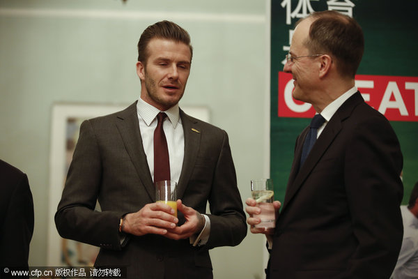 David Beckham talks with UK Ambassador to China Sebastian Wood, right, during his visit to the UK embassy to China in Beijing, on March 24, 2013, as his five-day China visit came to an end. Beckham catches up with Chinese culture on last stop