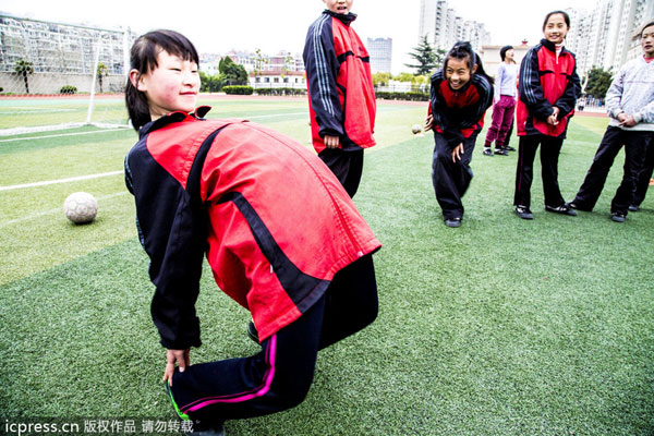 A female soccer player stretches during a training session in Nantong, East China's Jiangsu province, March 26, 2013. Soccer can be girls' sport