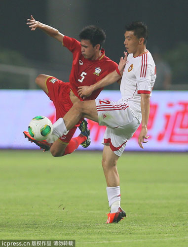 Yu Dabao, right, challenges a Thai player during China's 1-5 loss to Thailand in an international friendly in Hefei, Anhui province, June 15, 2013. Soccer national team concedes humiliating defeat