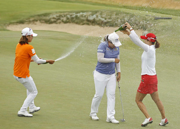Inbee Park (C) of South Korea is sprayed with champagne by compatriots Na-yeon Choi and So-yeon Ryo (R) after winning the 2013 US Women's Open golf championship at the Sebonack Golf Club in Southampton, New York, June 30, 2013. South Korean Park wins third consecutive major