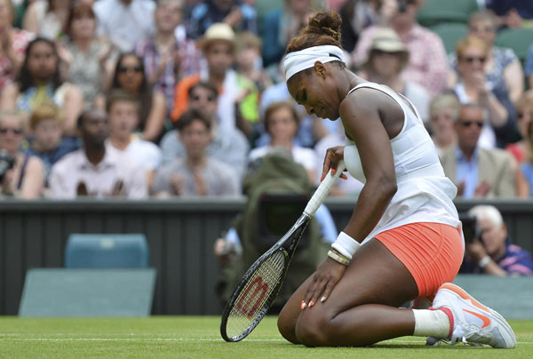 Serena Williams of the US recovers after diving for a shot during her women's singles tennis match against Sabine Lisicki of Germany at the Wimbledon Tennis Championships, in London, July 1, 2013. Lisicki stuns Serena in another Wimbledon shock