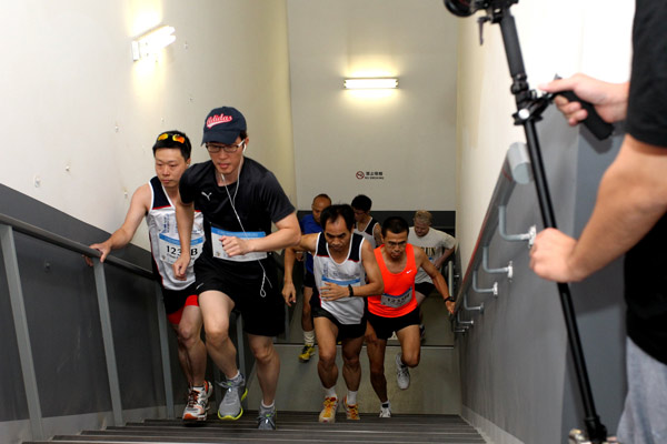 Runners climb up stairs during the vertical marathon at the inaugural China World Summit Wing Hotel Vertical Run in Beijing, on Aug 3, 2013. International vertical run debuts in Beijing