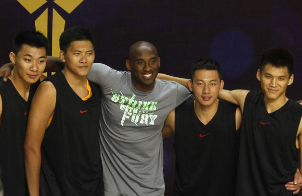 Los Angeles Lakers NBA star Kobe Byrant poses with basketball players during a basketball clinic in the southern Chinese city of Shenzhen August 4, 2013. Kobe Byrant meets fans in Shenzhen