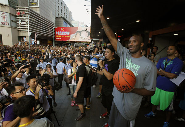 Los Angeles Lakers NBA star Kobe Byrant waves to fans as thousands cheer outside a sport store in the southern Chinese city of Shenzhen August 4, 2013. Kobe Byrant meets fans in Shenzhen